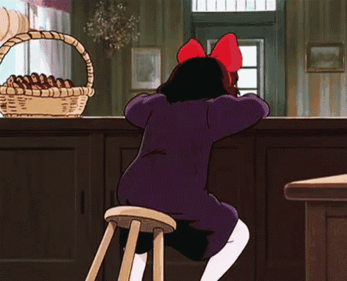a girl in a purple dress with a red bow is sitting on a stool
