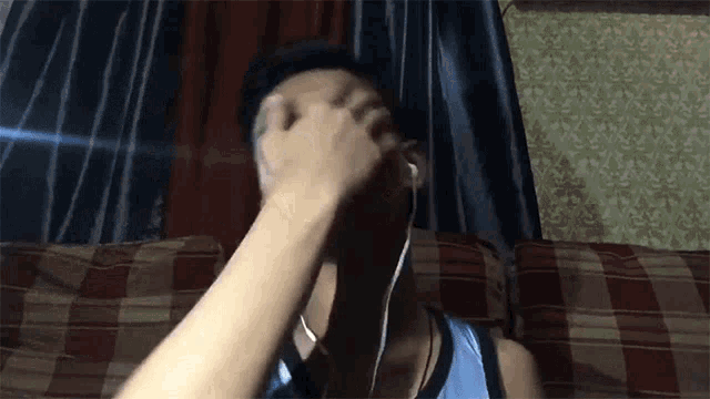 a man laying on a couch with headphones on