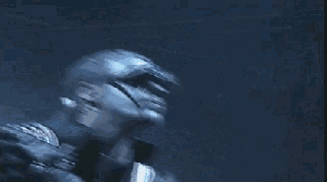 a man wearing sunglasses is singing into a microphone in a dark room