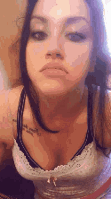 a woman with a tattoo on her chest is wearing a bra