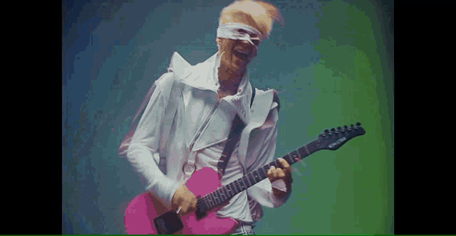 a man with bandages on his eyes is playing a pink electric guitar