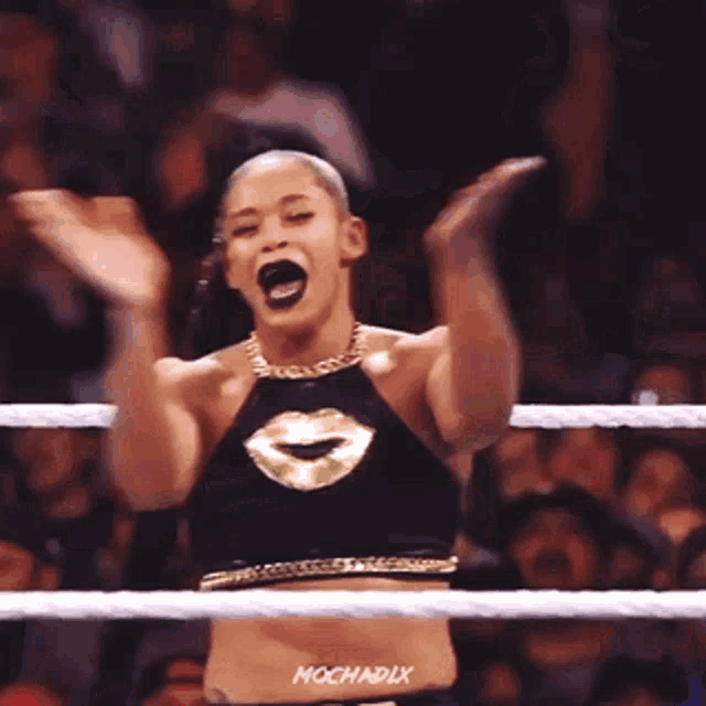 a woman is standing in a wrestling ring with the name mochadix on the bottom of her waist