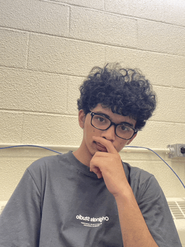 a young man wearing glasses and a t-shirt that says olbuz2 alrighto