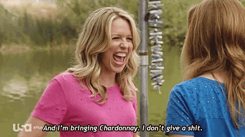 a woman in a pink shirt is laughing while talking to another woman in a blue shirt with usa written on the bottom
