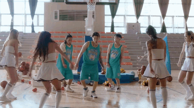 a group of cheerleaders and basketball players on a court with one wearing a jersey that says ' thunder '