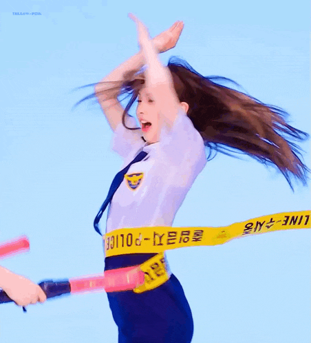 a woman in a white shirt and blue pants is throwing her hair in the air