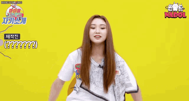 a girl with long hair is sitting in a chair with her arms outstretched and a white shirt on .