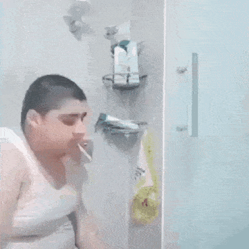 a woman is taking a shower in a bathroom and holding a towel .
