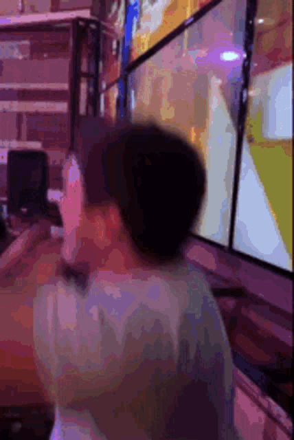 a man is playing a video game in front of a bunch of screens