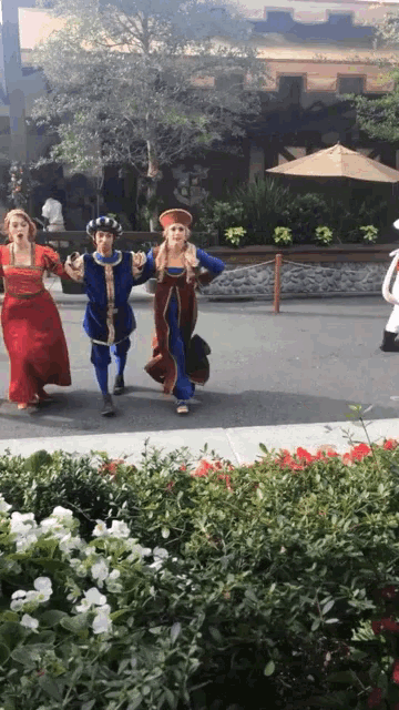 a group of people dressed in costumes are walking down the street