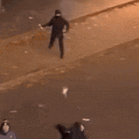 a person is walking down a sidewalk at night with their shadow on the ground .