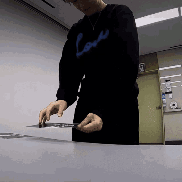 a person wearing a black sweatshirt that says love on it