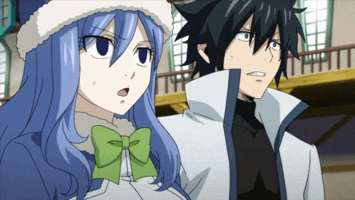 a boy and a girl are standing next to each other and the girl has a green bow in her hair