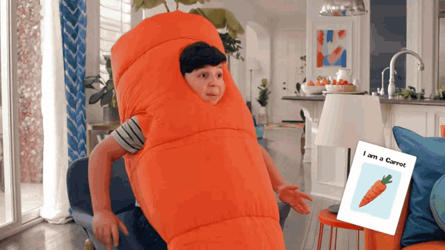 a child dressed as a carrot with a picture of a carrot