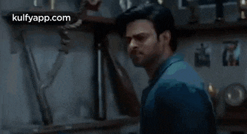 a man is holding another man 's neck in a dark room .