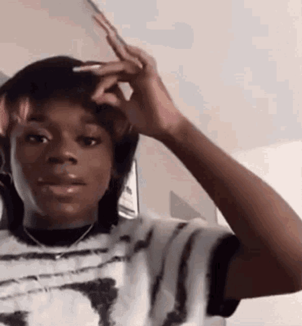a woman with long nails is brushing her hair with a pair of scissors .