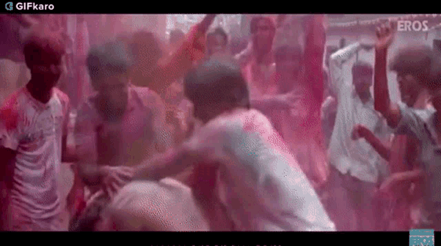 a group of people are playing with colored powder .