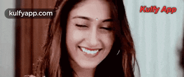 a woman is smiling with her eyes closed and the words kulfyapp.com on the bottom