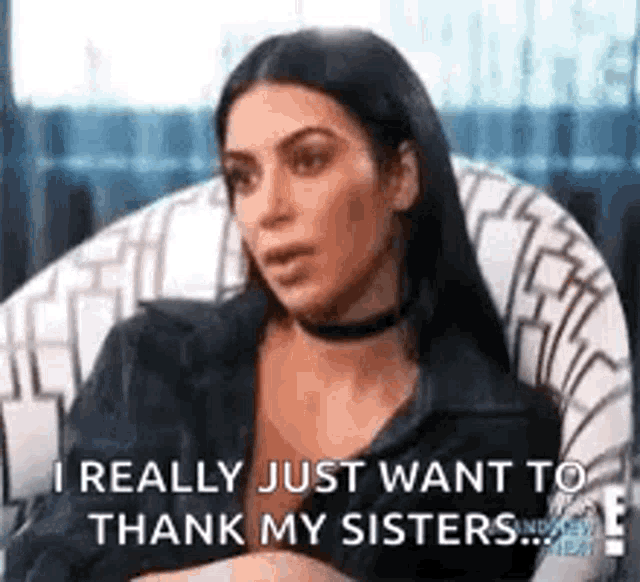 kim kardashian is sitting in a chair and talking to her sisters .