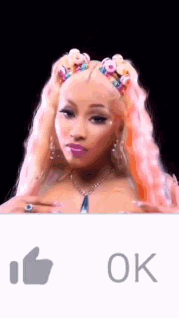 a woman with pink hair is giving a thumbs up