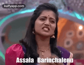 a woman is making a funny face while wearing a purple saree and a pink top .