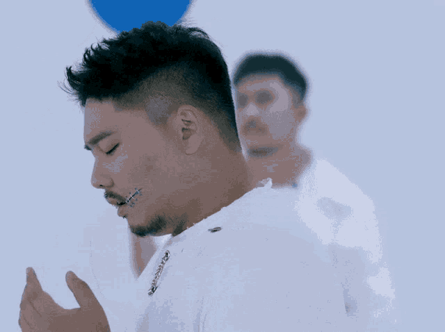 a man in a white shirt has a tattoo on his face that says ' i 'm sorry '