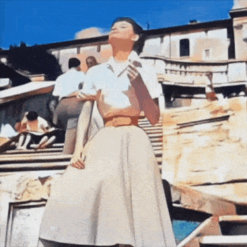 a woman in a white dress is standing in front of a fountain