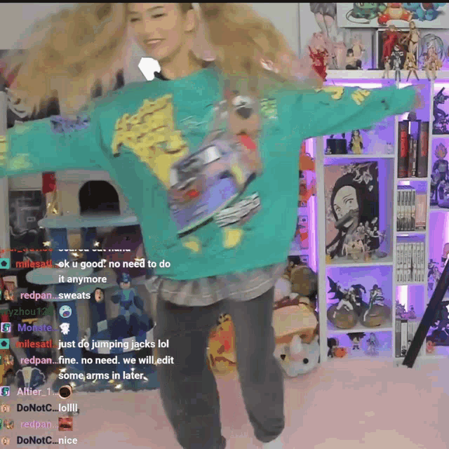a girl in a green sweater is dancing in front of a shelf full of figurines and toys