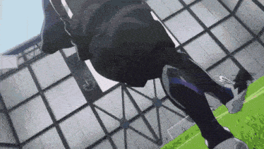 a soccer player is kicking a soccer ball on a field in front of a building .
