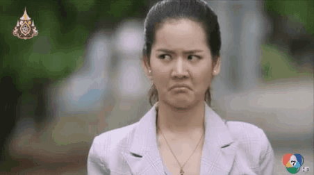 a woman in a suit is making a funny face with the number 7 in the background