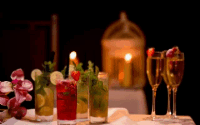 a table topped with a variety of drinks including a strawberry mojito