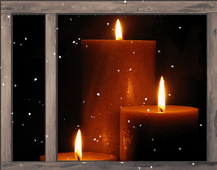 three candles are lit in a window with snow falling