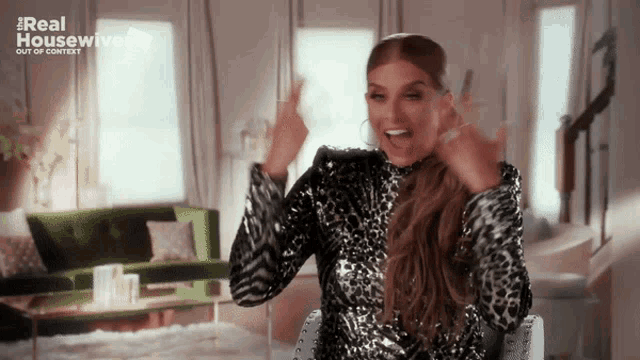 a woman in a leopard print dress is sitting in a living room with the words real housewives out of context on the bottom right