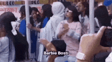 a group of people are standing in a line and one of them is wearing a barbie bosti costume