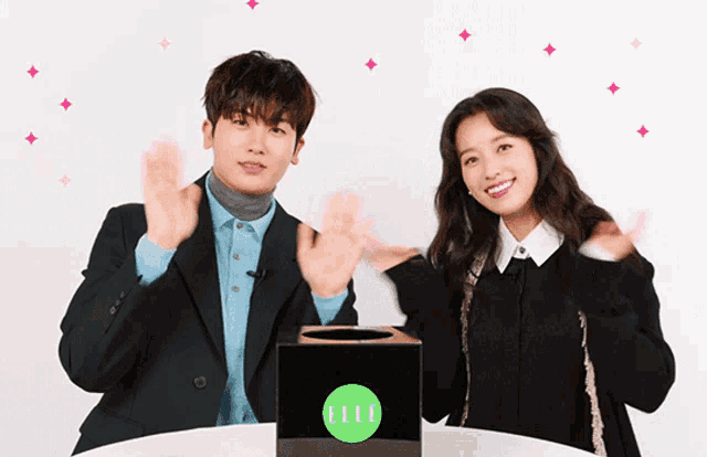 a man and a woman standing in front of a box that says elle