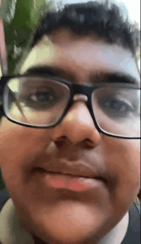 a close up of a person wearing glasses and making a funny face .