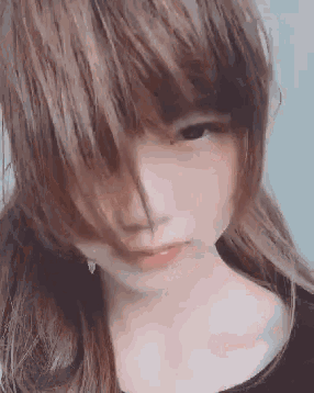 a close up of a woman 's face with long hair and a black shirt