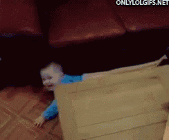 a baby is crawling through a cardboard box on the floor .