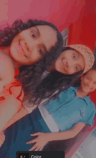 two girls and a boy are posing for a picture together and smiling for the camera .