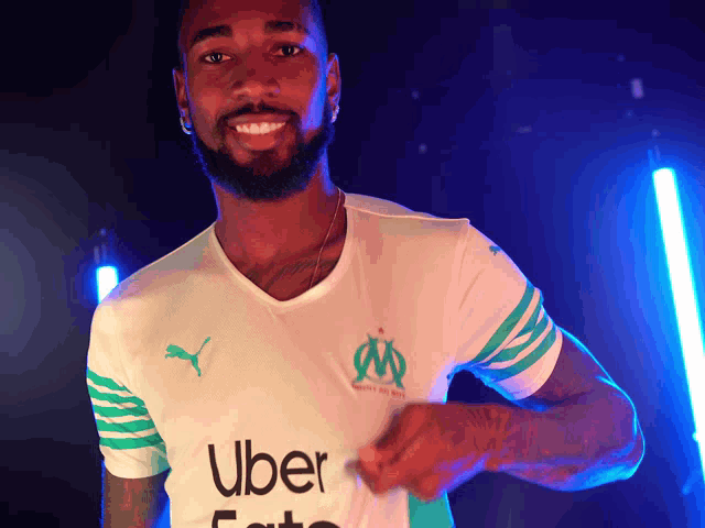 a man is wearing a white shirt with uber written on it
