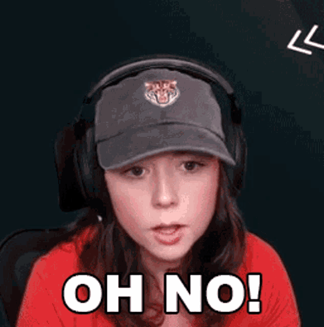 a woman wearing headphones and a baseball cap says oh no