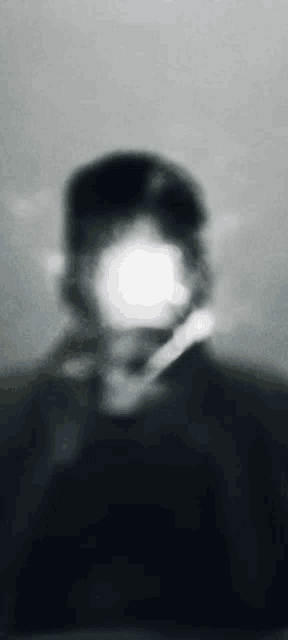 a blurry picture of a man 's face behind a glass .