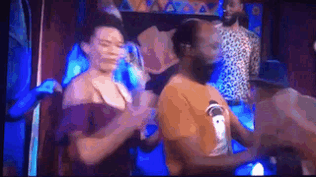 a man and a woman are dancing on a stage in a club .
