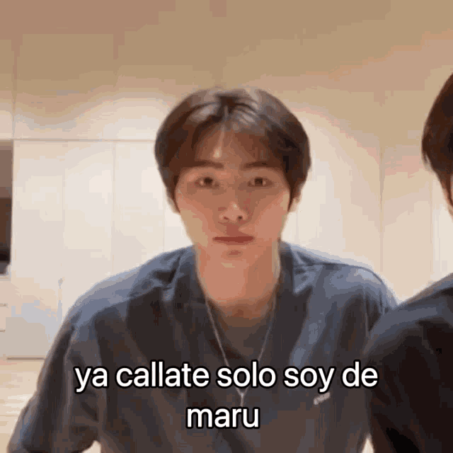 a young man is wearing a blue shirt and a necklace and says ya callate solo soy de maru