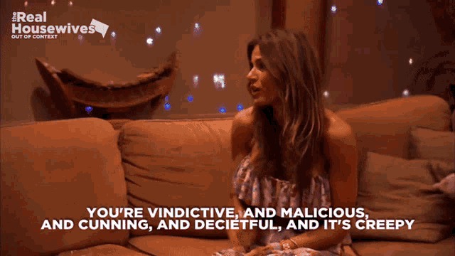 a woman sitting on a couch with the words " you 're vindictive and malicious and cunning "