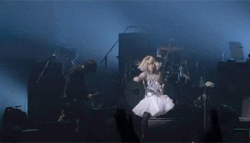 a woman in a white dress dancing on a stage