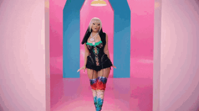 a woman in a corset and thigh high boots is walking through a pink and blue hallway .