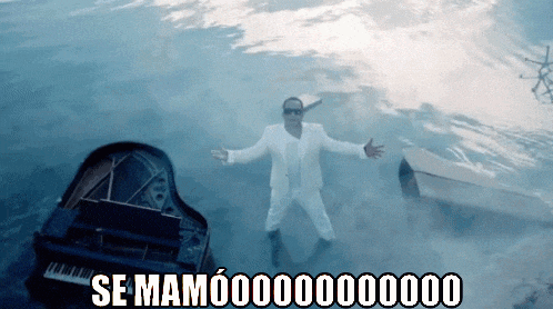 a man in a white suit is standing in the water next to a piano that says se mamoooooo