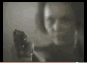 a blurry picture of a woman pointing a gun at the camera