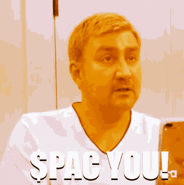 a man in a white shirt is holding a cell phone and the words spac you are above him